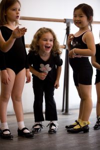 Three smiling First Steps Tap Students at the Steps on Broadway Academy