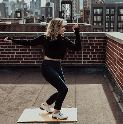 Shelby Kaufman tap dancing on a roof in the city